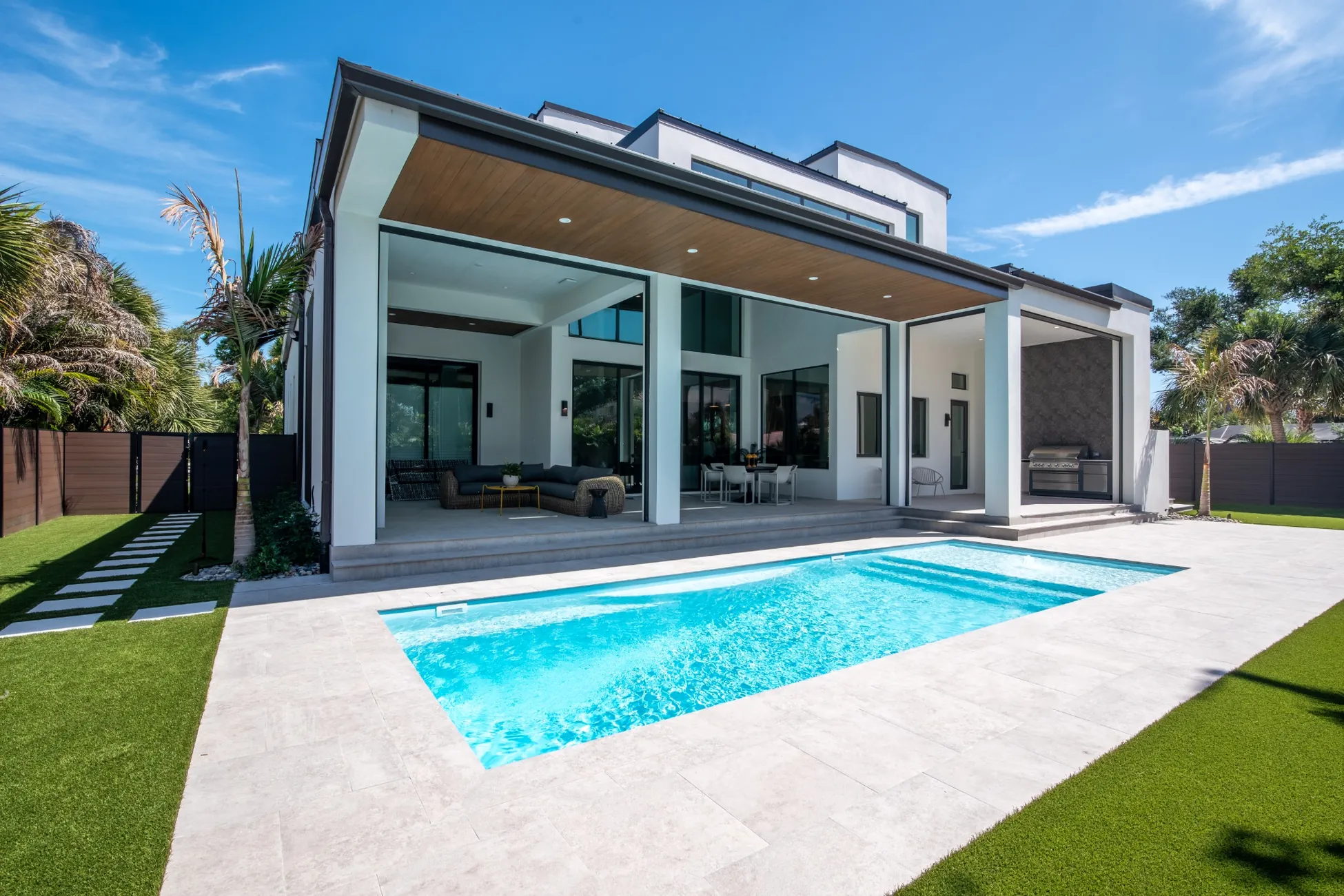 Luxury modern custom home with pool and covered patio outdoor living space in Vero Beach FL