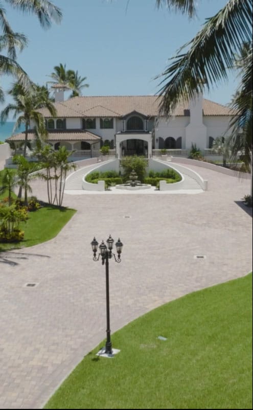 Custom home builder Vero Beach FL luxury waterfront home with circular driveway and palm trees